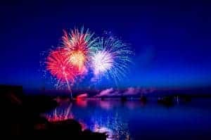A colorful fireworks display over a body of water.