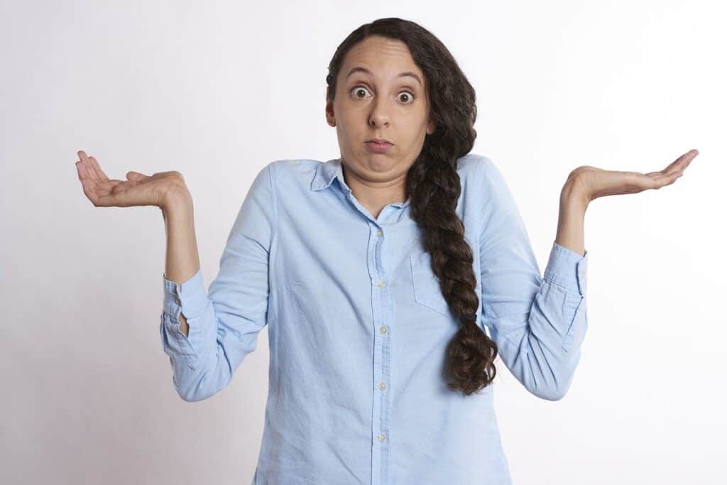 A woman with her hands outstretched in front of a white background.